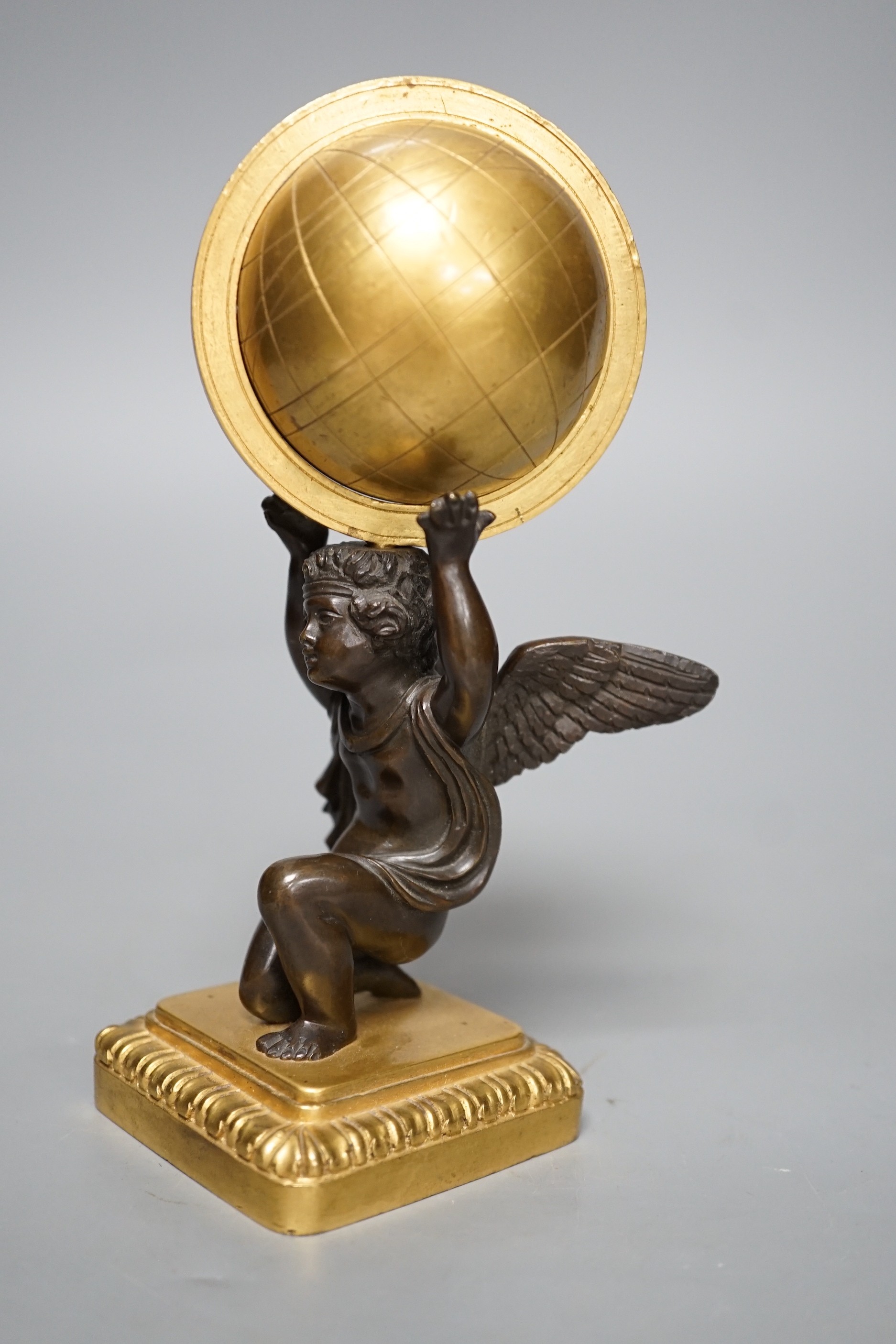 A late 19th century bronze and ormolu model of a cherub supporting a globe, 16cm